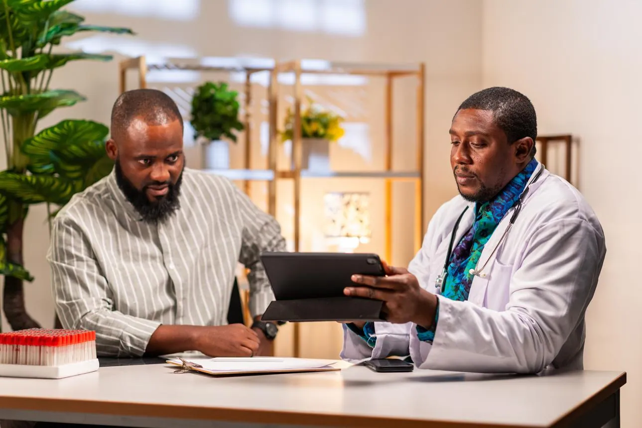 A clinician reviewing a health assessment with a patient on a tablet